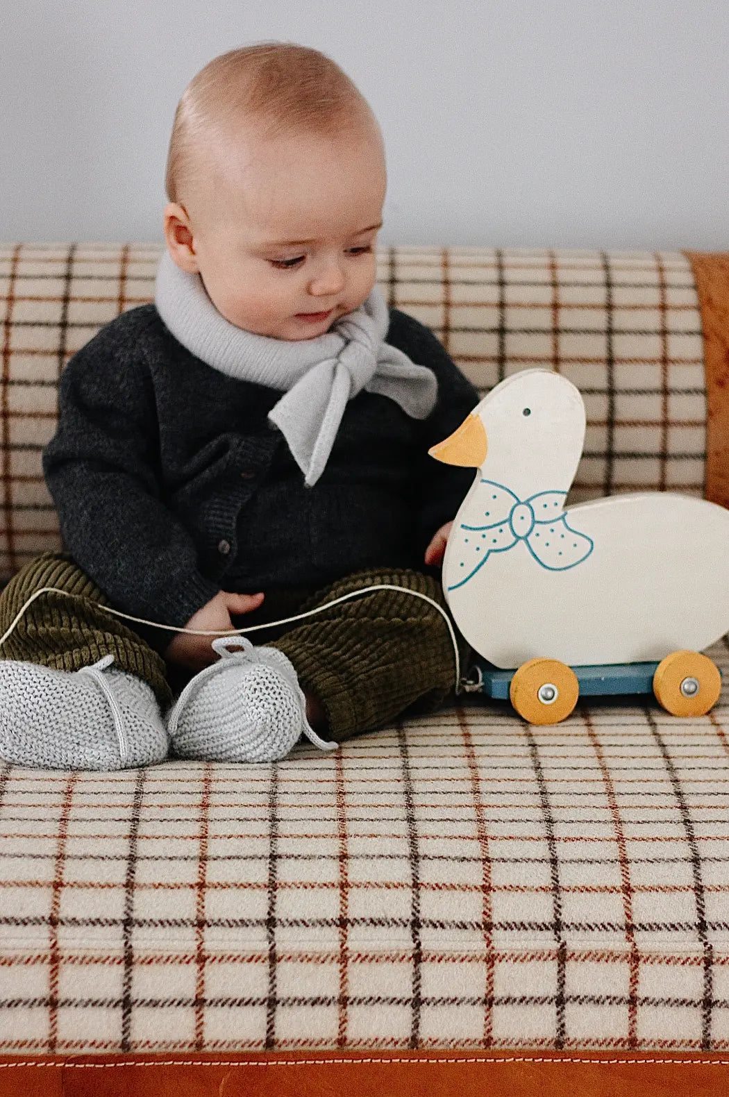 Baby boy wearing Lalaby knitted Alpha shoe and Altas scarf in bluey light blue cashmere