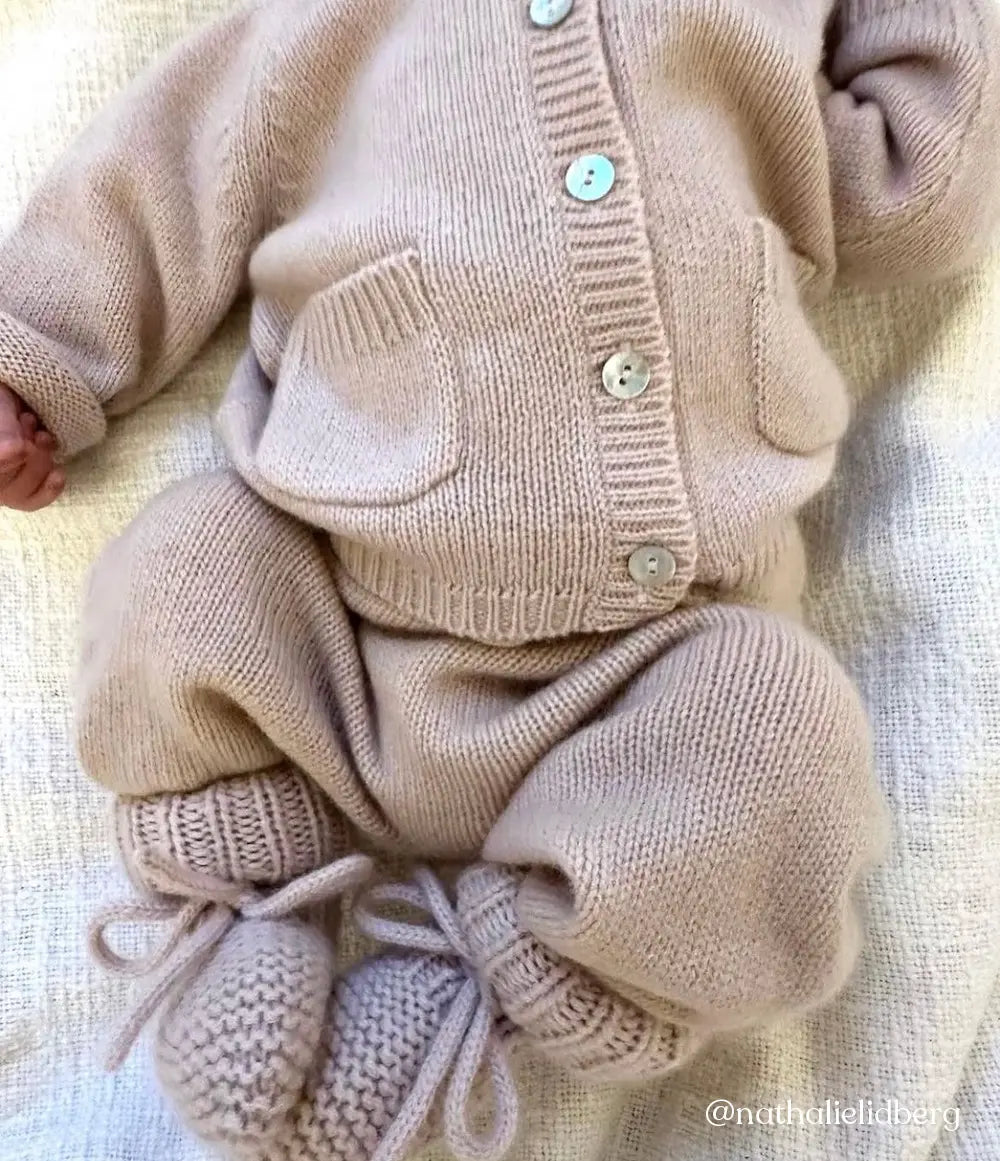 Baby wearing full Lalaby outfit in powder pink cashmere, including a Bobbie cardigan, stormy pants and alpha shoes