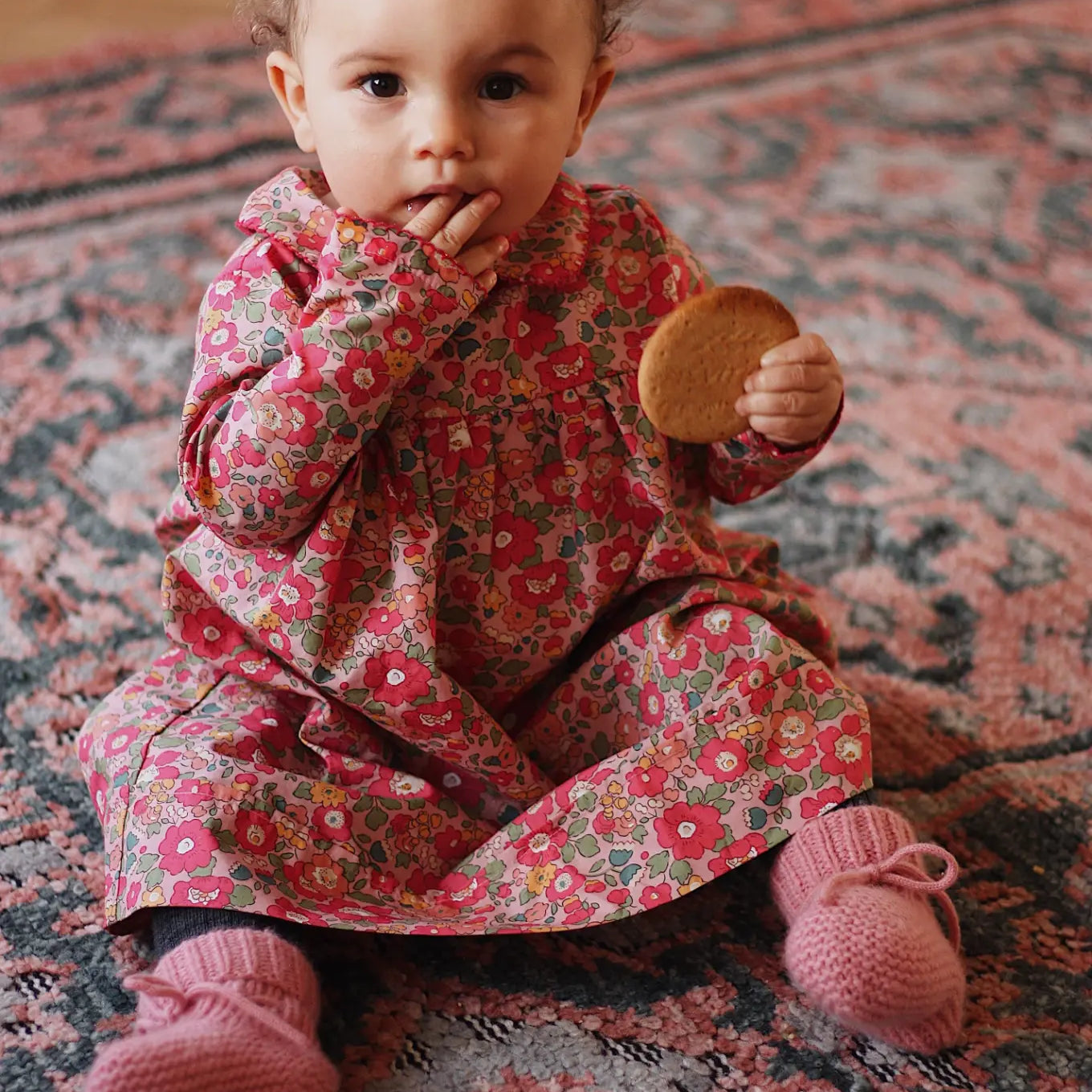 Baby girl wearing Lalaby Anna baby dress in Berry besty pink liberty organic cotton