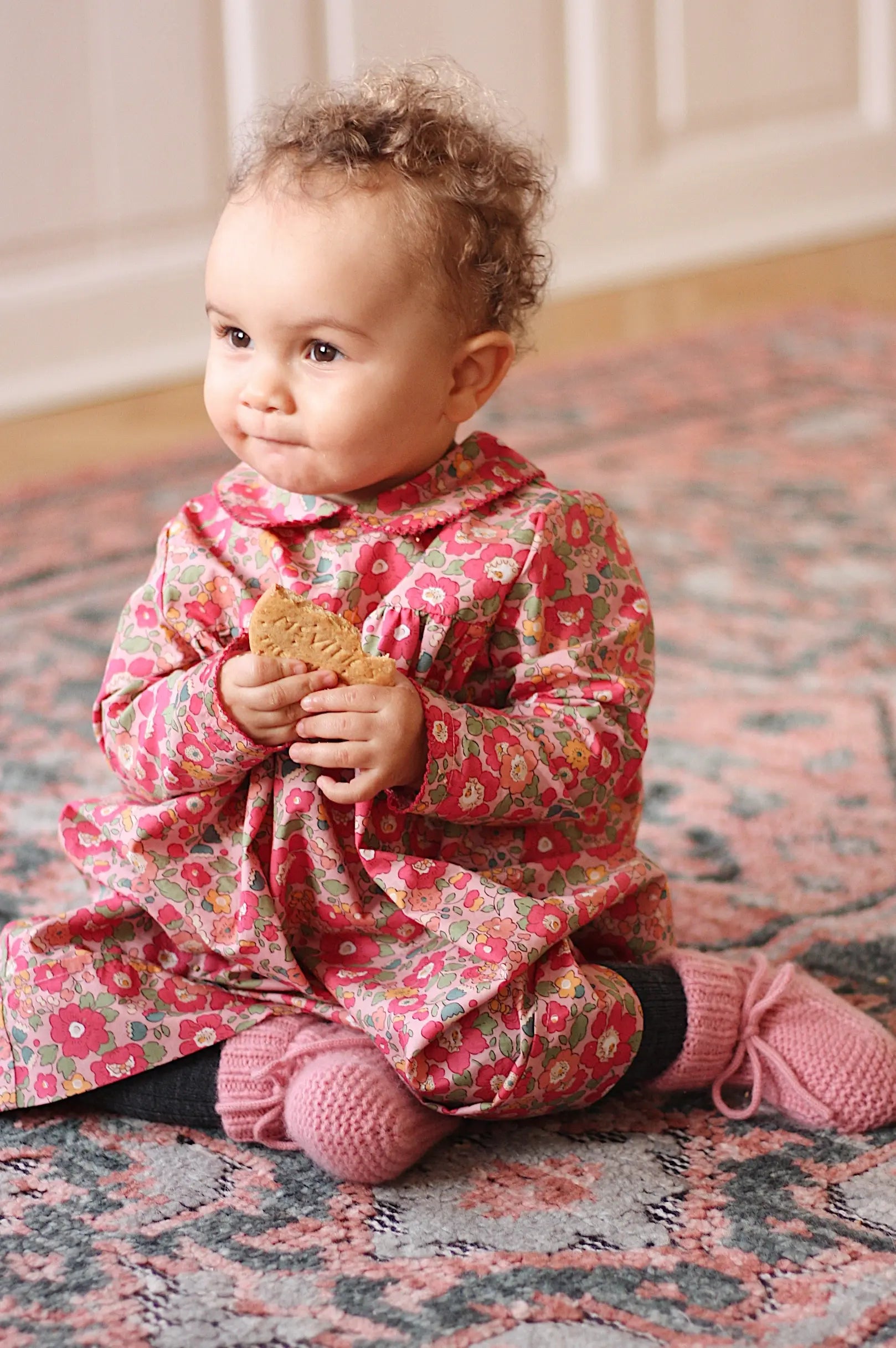 Baby girl wearing Lalaby Anna baby dress in Berry besty pink liberty organic cotton