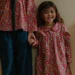 Girl wearing Lalaby Anna dress for kids in berry betsy pink liberty organic cotton