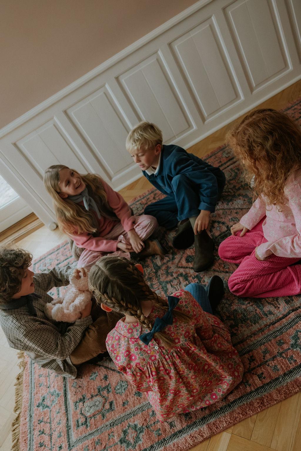 Girl wearing Lalaby Anna dress for kids in berry betsy pink liberty organic cotton