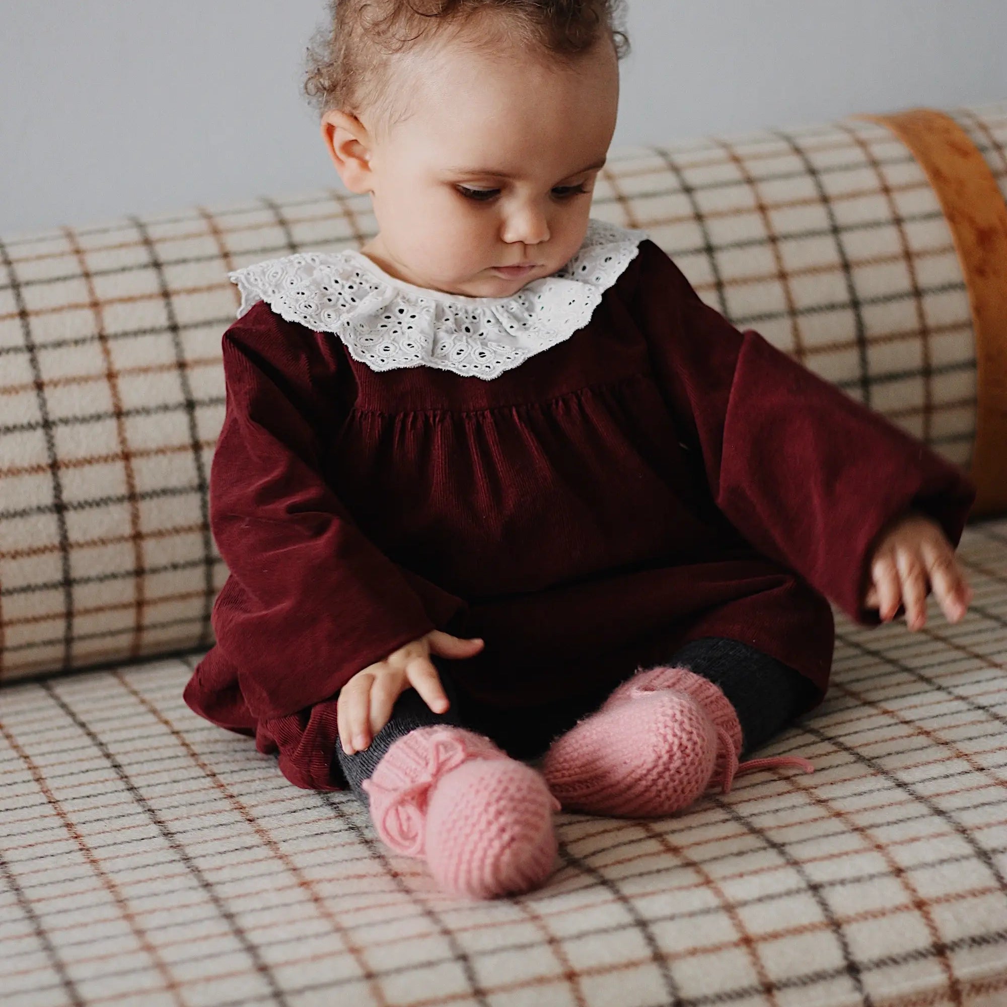 Baby girl wearing Lalaby Annabella dress for babies in ruby red cotton baby cord