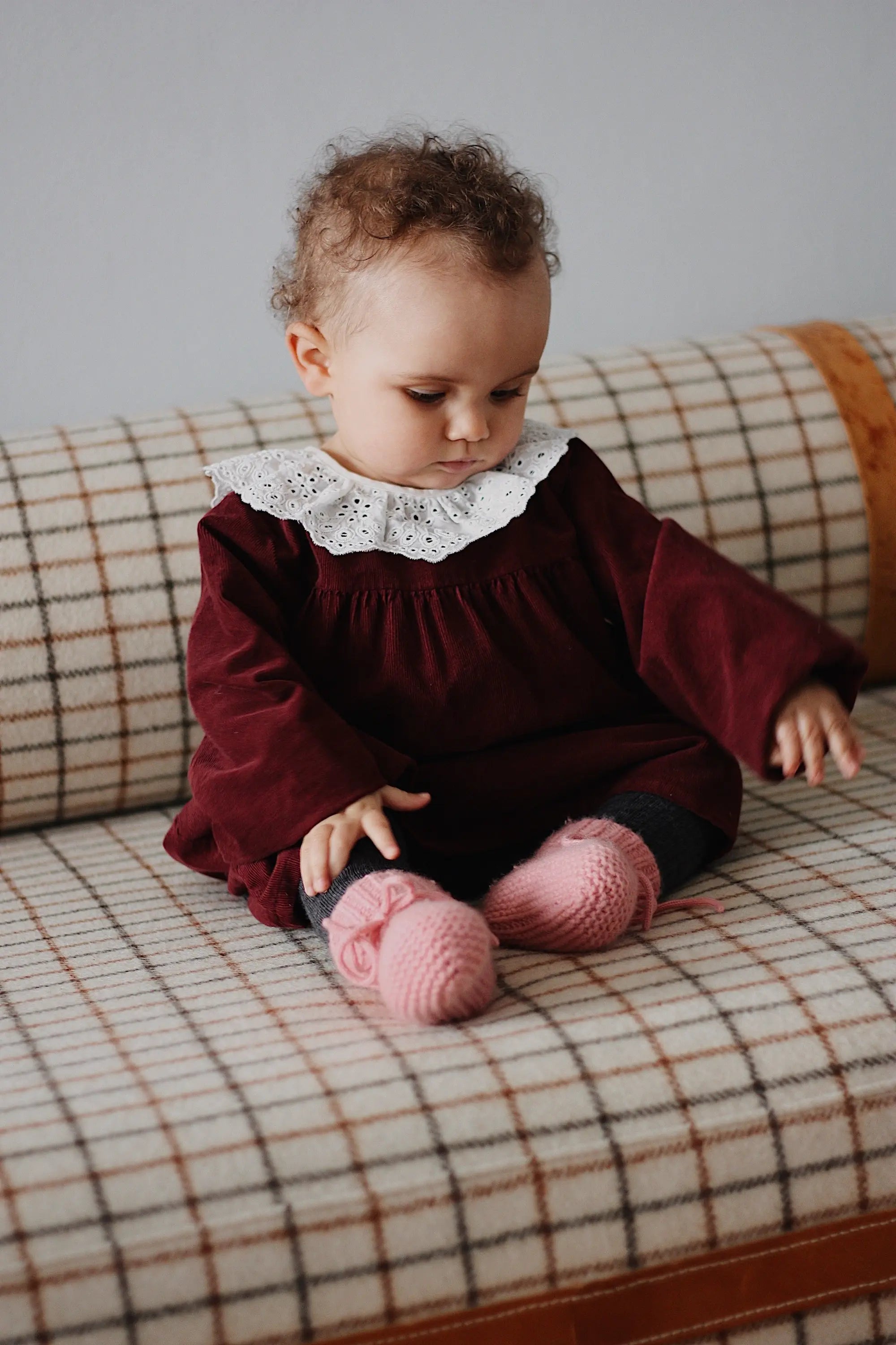 Baby girl wearing Lalaby Annabella dress for babies in ruby red cotton baby cord
