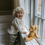 Boy wearing Lalaby Aran sweater for kids in natural white merino wool