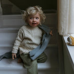 Boy wearing Lalaby Aran sweater for kids in natural white merino wool