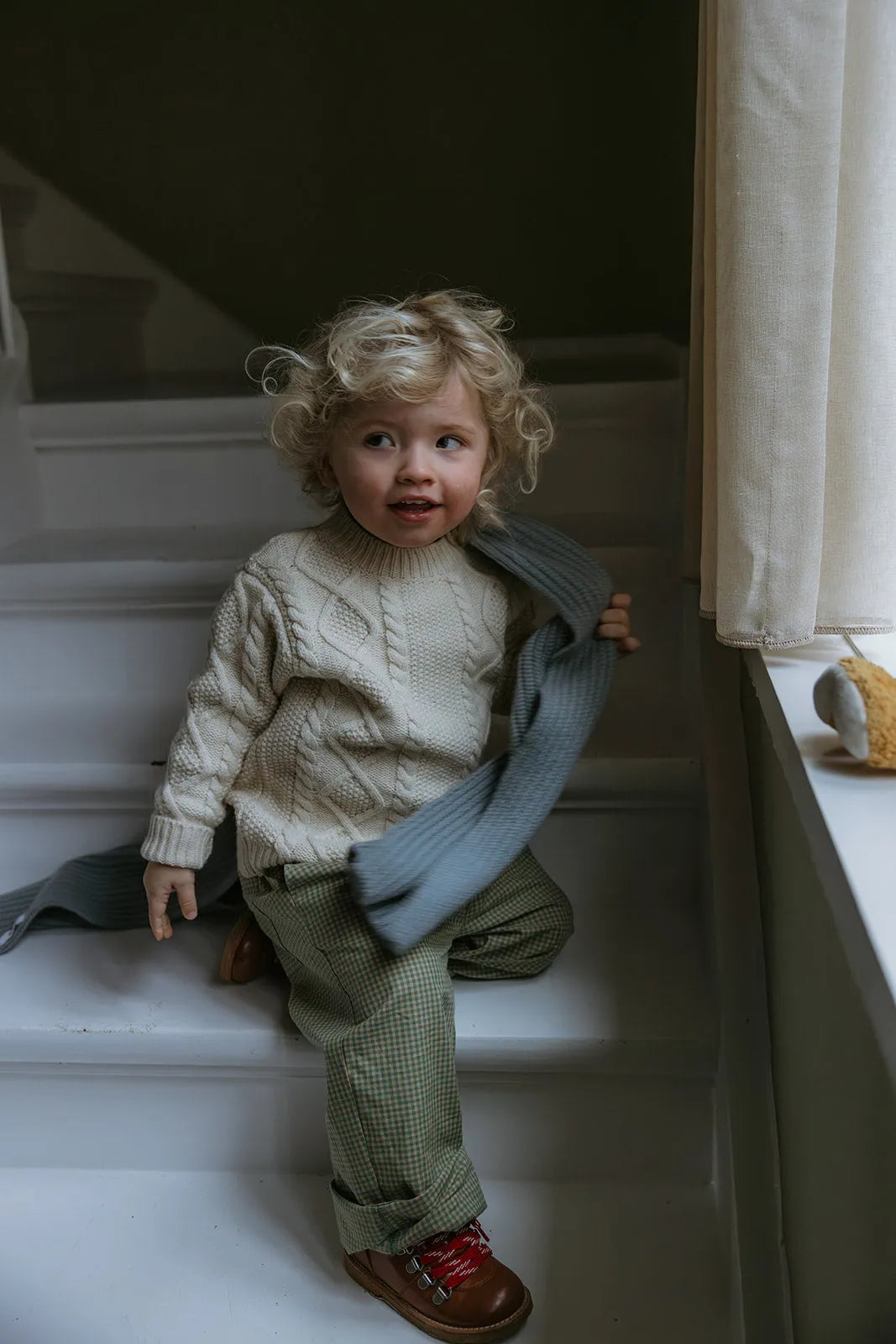 Boy wearing Lalaby Aran sweater for kids in natural white merino wool