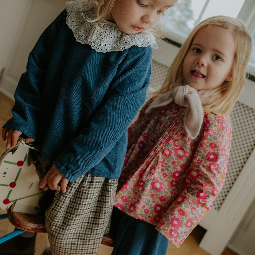 Girl wearing Lalaby Atlas scarf in powder pink cashmere