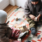 Baby girl wearing Lalaby Babar baby jacket in hazel brown merino wool