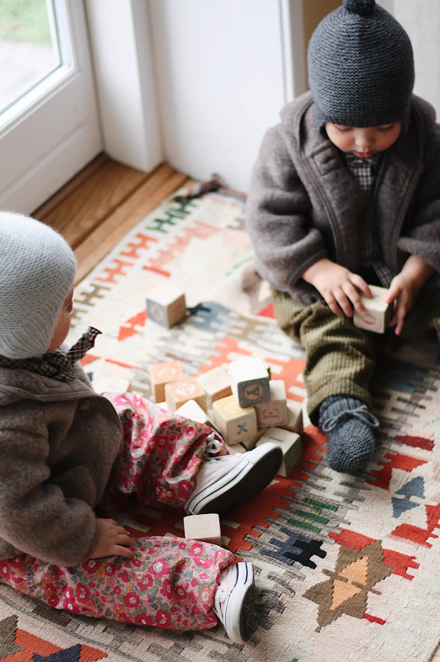 Baby girl wearing Lalaby Babar baby jacket in hazel brown merino wool