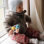 Baby girl wearing Lalaby Babar baby jacket in hazel brown merino wool