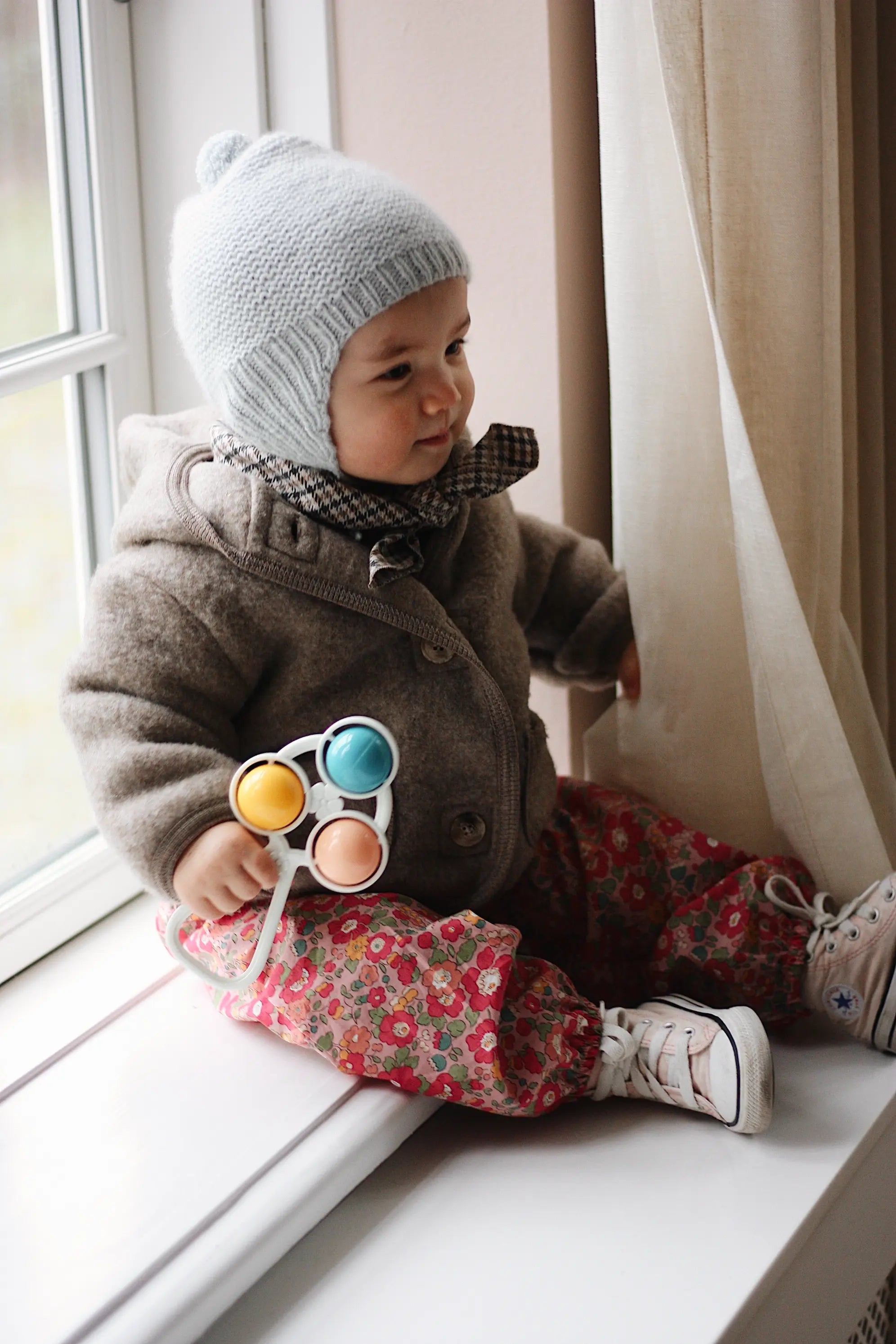 Baby girl wearing Lalaby Babar baby jacket in hazel brown merino wool