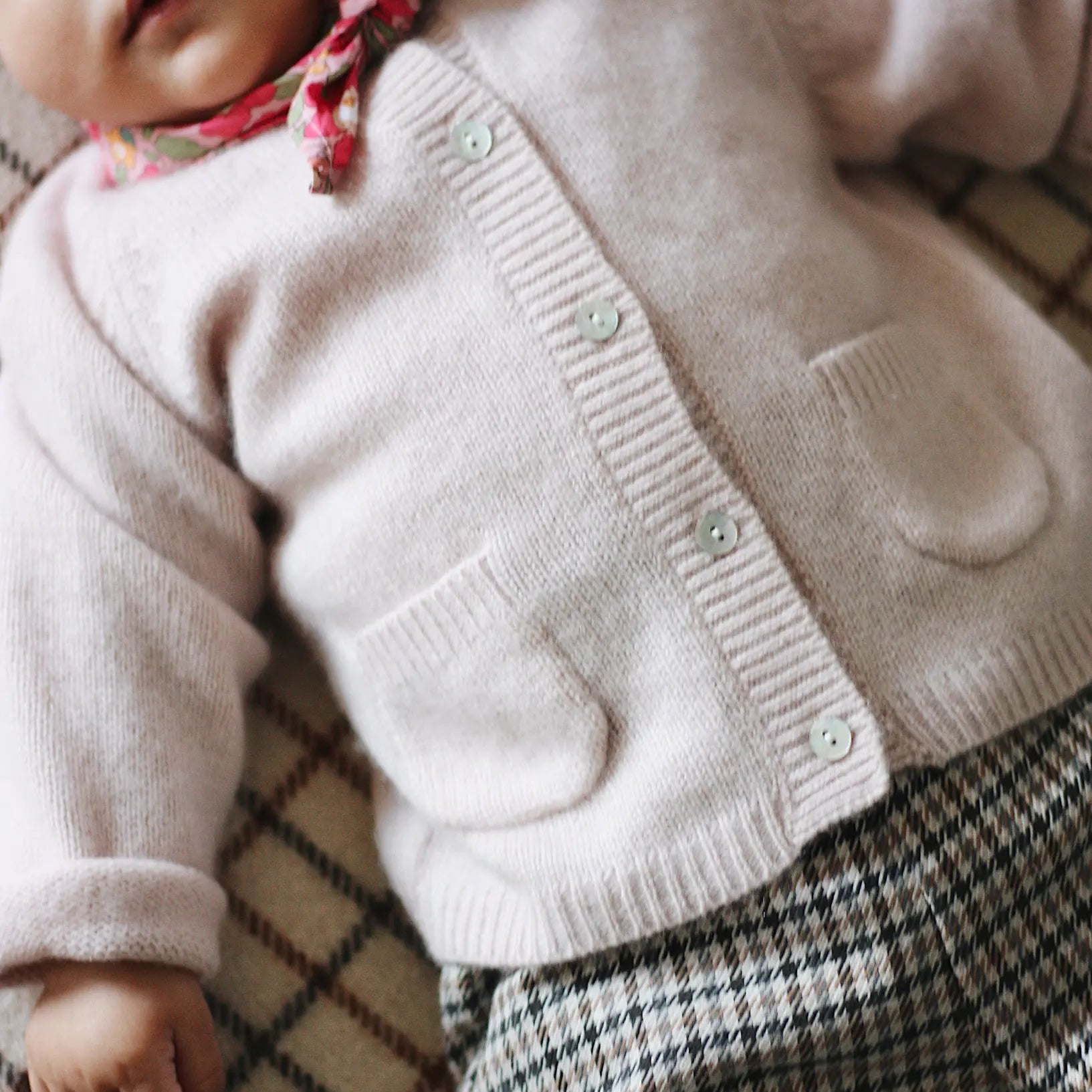 Baby girl wearing Lalaby Bobbie baby cardigan in powder pink cashmere