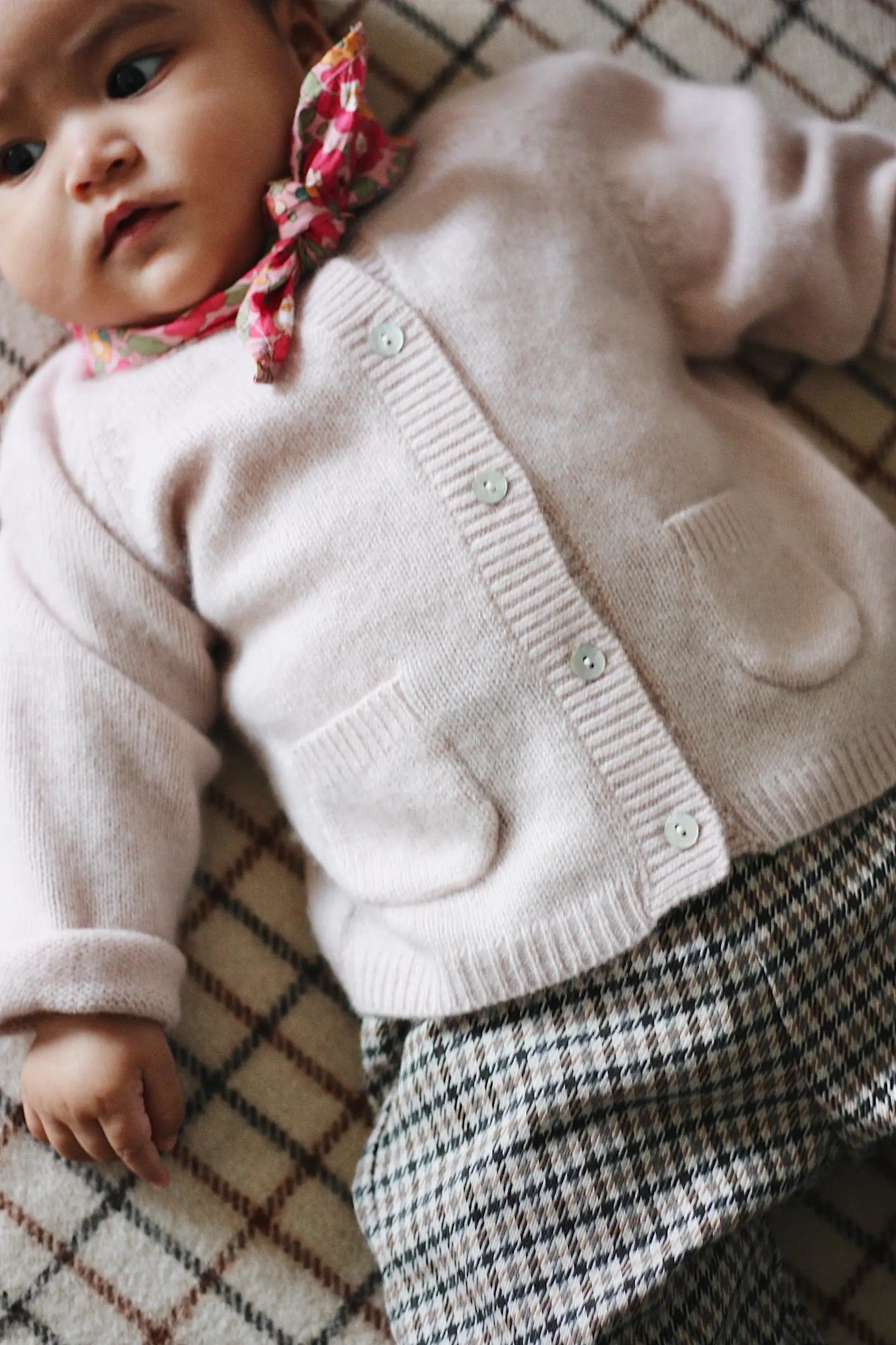 Baby girl wearing Lalaby Bobbie baby cardigan in powder pink cashmere