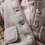 Baby girl wearing Lalaby Bobbie baby cardigan in powder pink cashmere