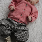Baby wearing Lalaby Bobbie cardigan in sorbet pink cashmere