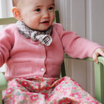 Baby girl wearing Lalaby Bobbie baby cardigan in sorbet pink cashmere