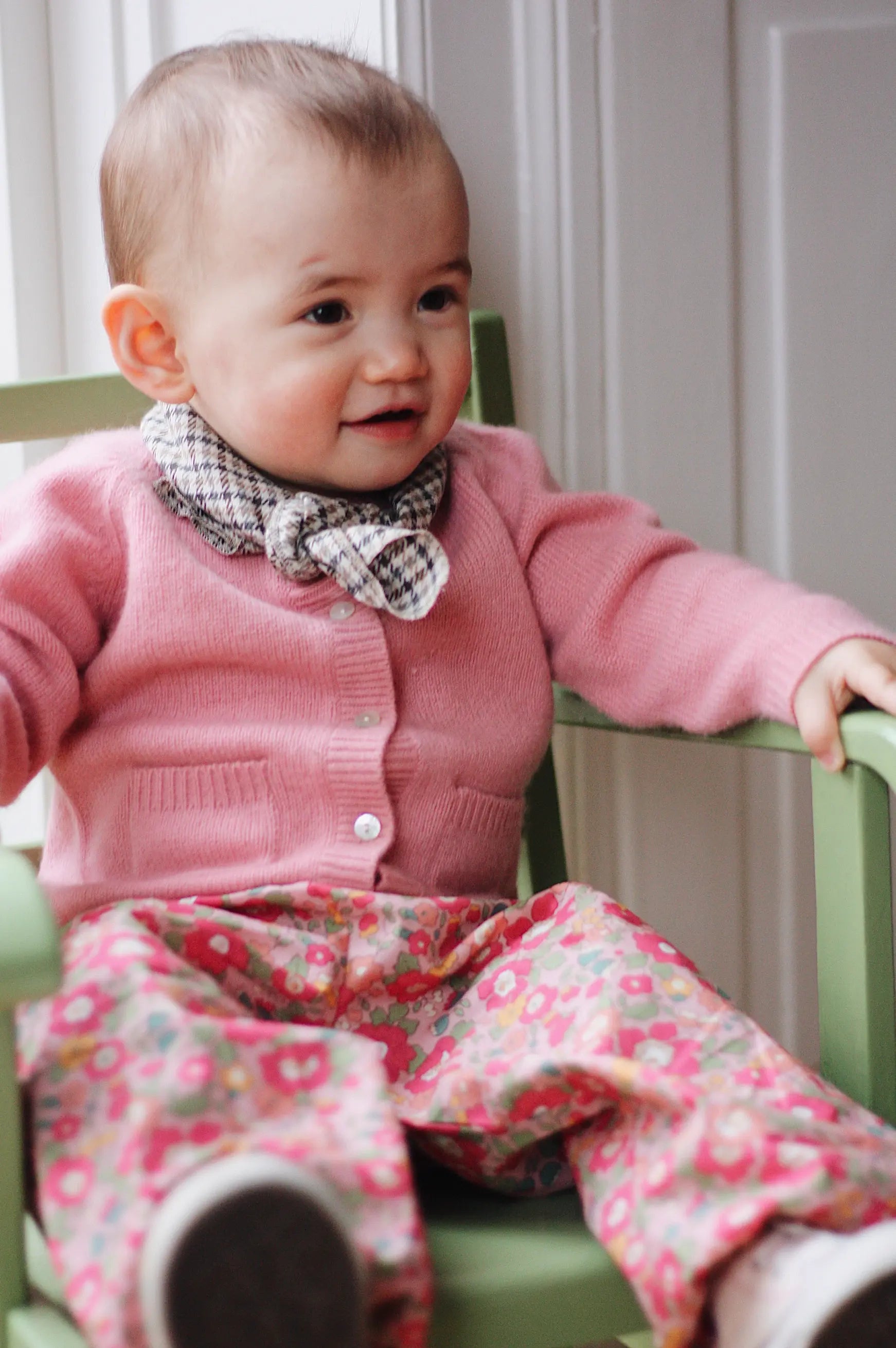 Baby girl wearing Lalaby Bobbie baby cardigan in sorbet pink cashmere