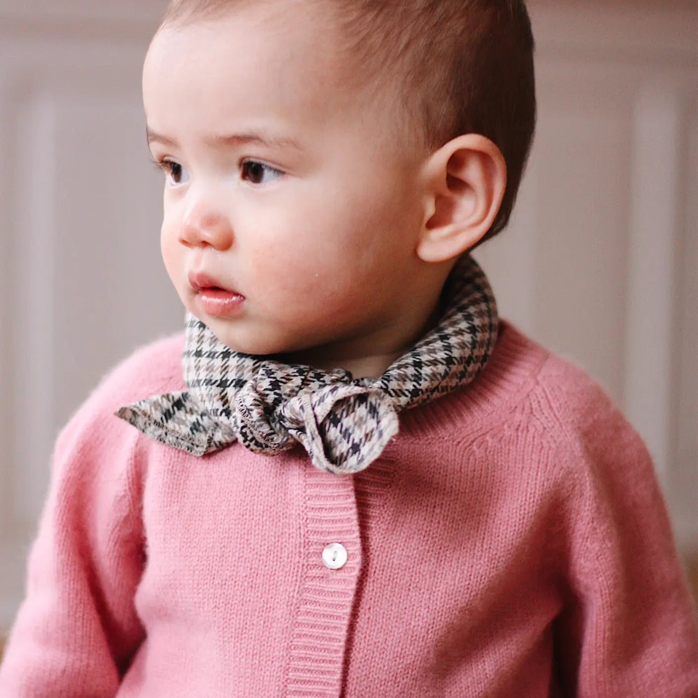 Baby girl wearing Lalaby Bobbie baby cardigan in sorbet pink cashmere