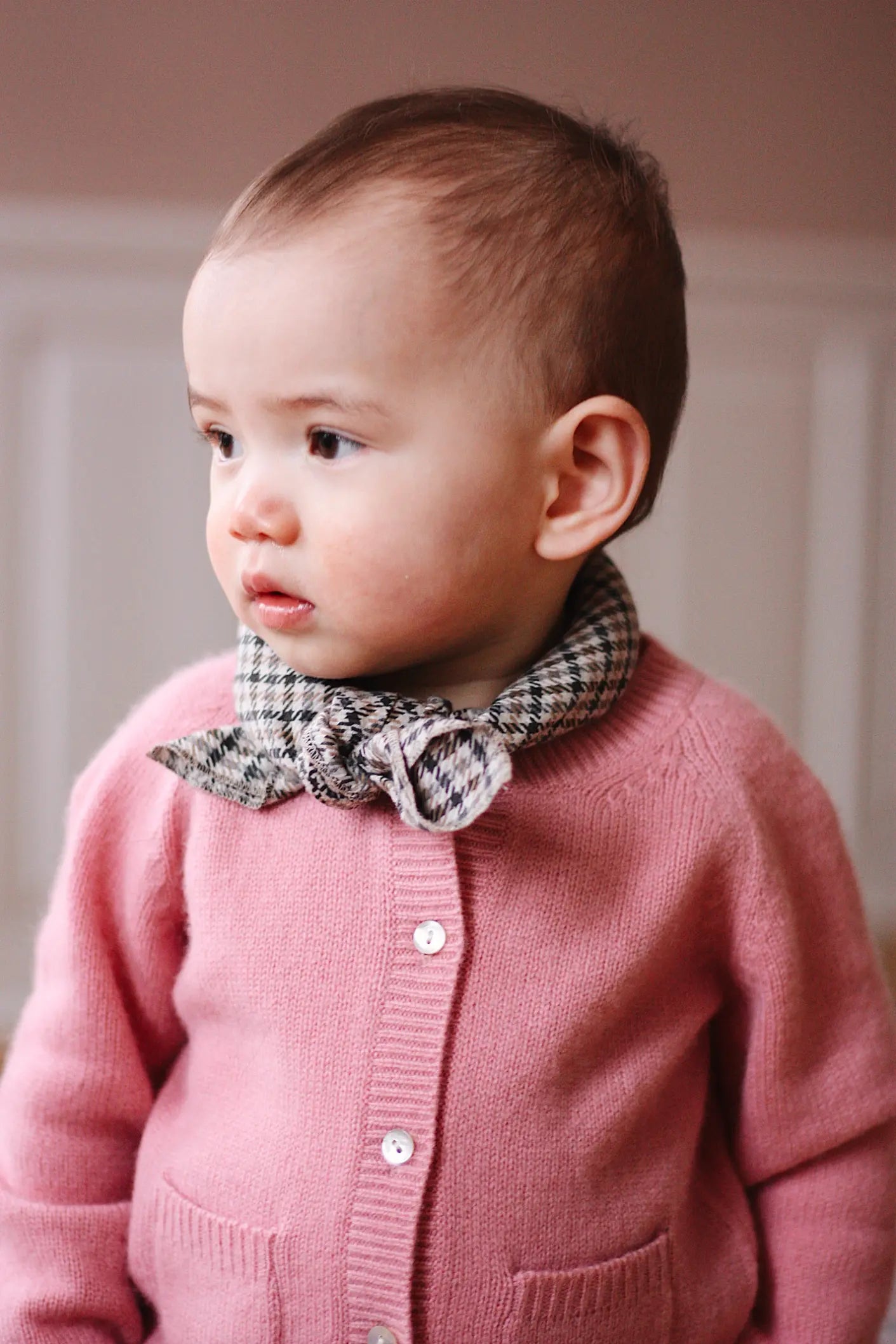 Baby girl wearing Lalaby Bobbie baby cardigan in sorbet pink cashmere