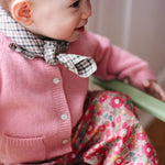 Baby girl wearing Lalaby Bobbie baby cardigan in sorbet pink cashmere
