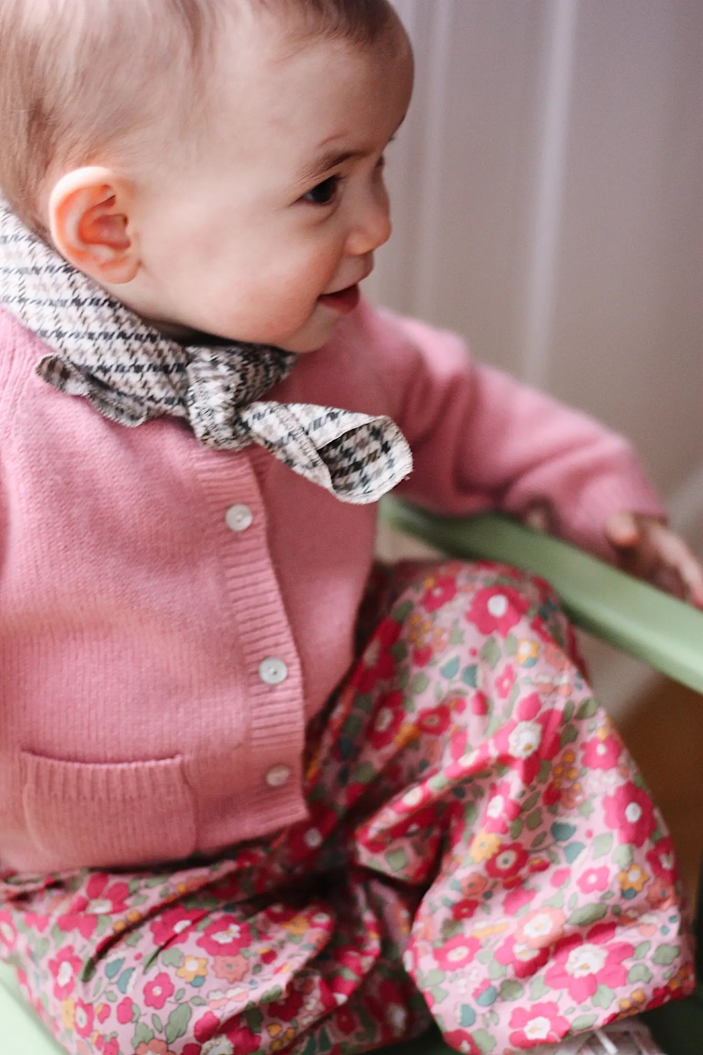 Baby girl wearing Lalaby Bobbie baby cardigan in sorbet pink cashmere