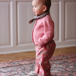 Baby girl wearing Lalaby Bobbie baby cardigan in sorbet pink cashmere