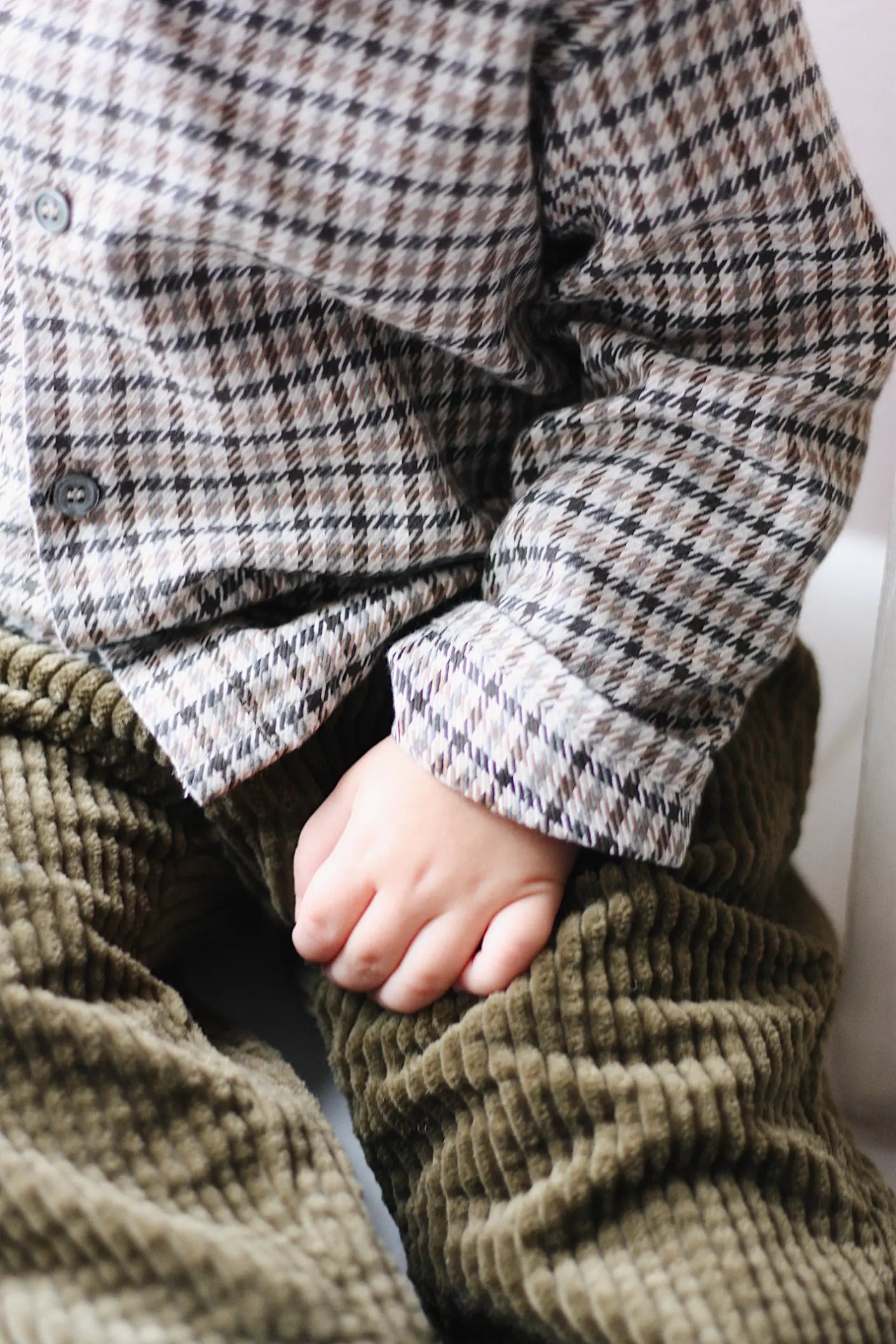 Baby boy wearing Lalaby Charlie baby trousers in forest green cotton mega corduroy