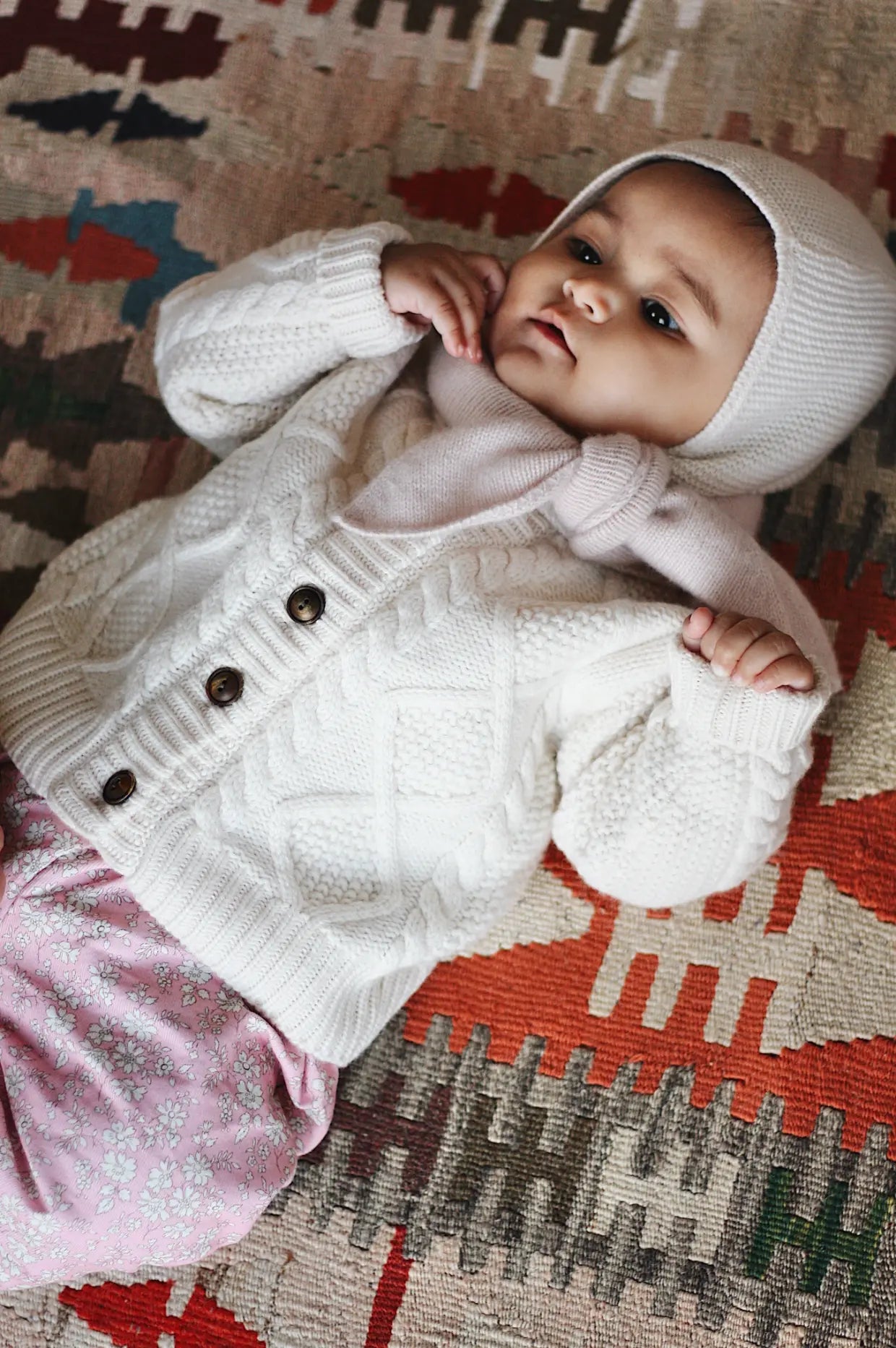 Baby girl wearing Lalaby Coby baby cardigan in natural white merino wool