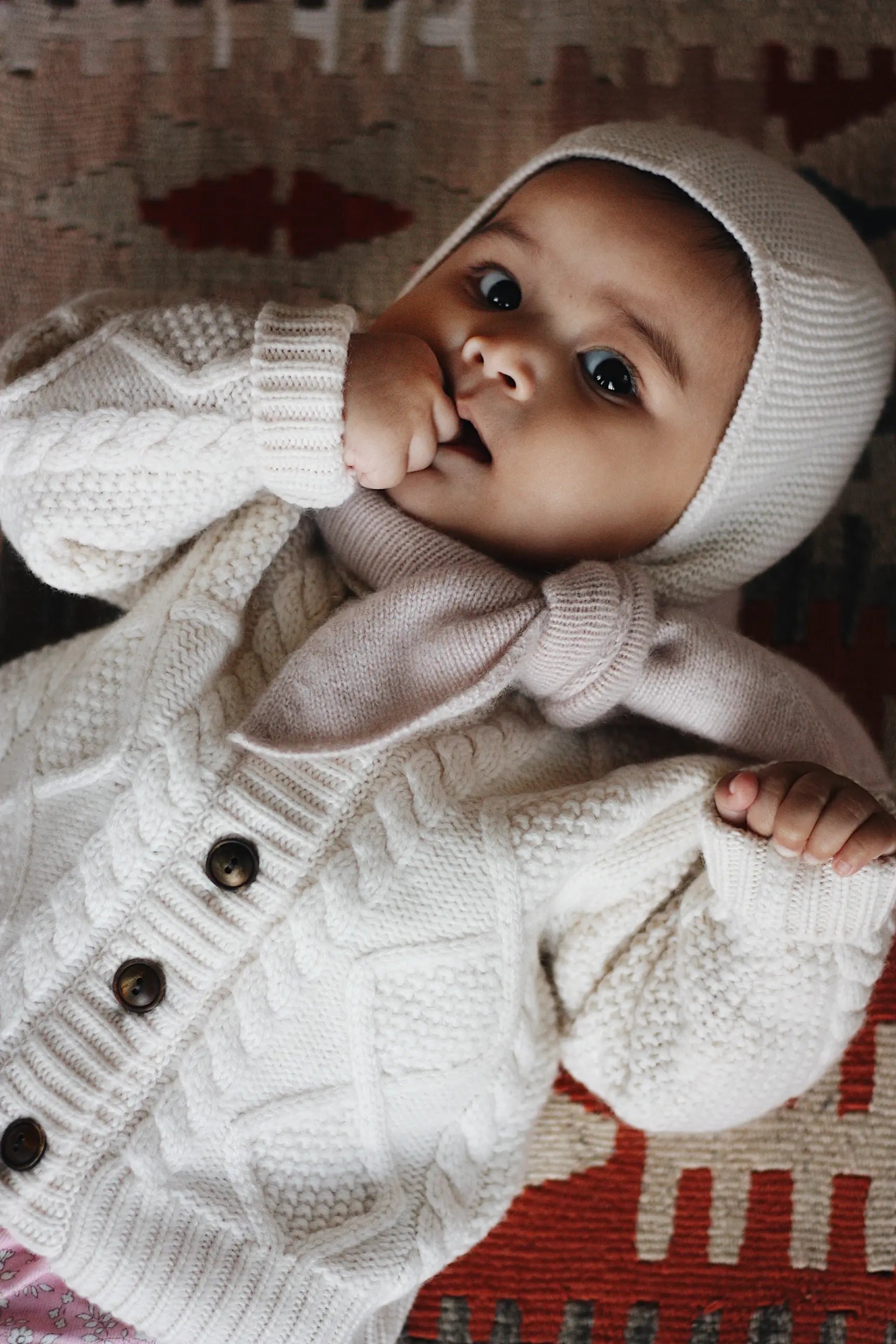 Baby girl wearing Lalaby Coby baby cardigan in natural white merino wool