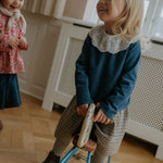 Girl wearing Lalaby Dagmar skirt for kids in tweedy check organic cotton