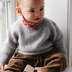 Baby girl wearing Lalaby Eddie scarf for babies and kids in Berry besty pink liberty organic cotton