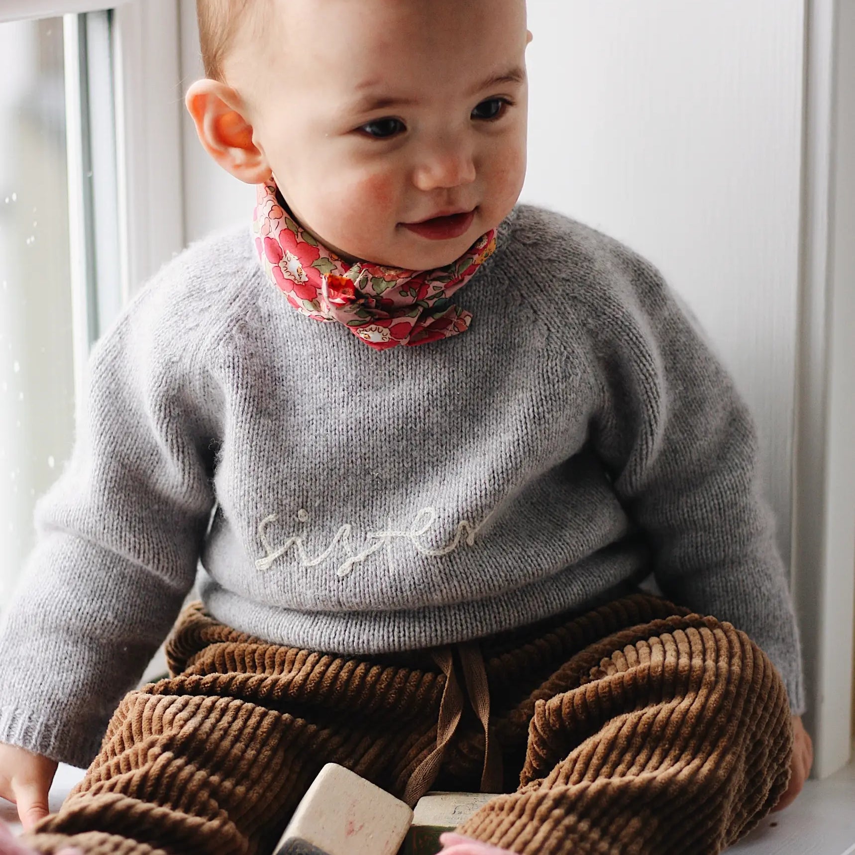 Baby girl wearing Lalaby Eddie scarf for babies and kids in Berry besty pink liberty organic cotton