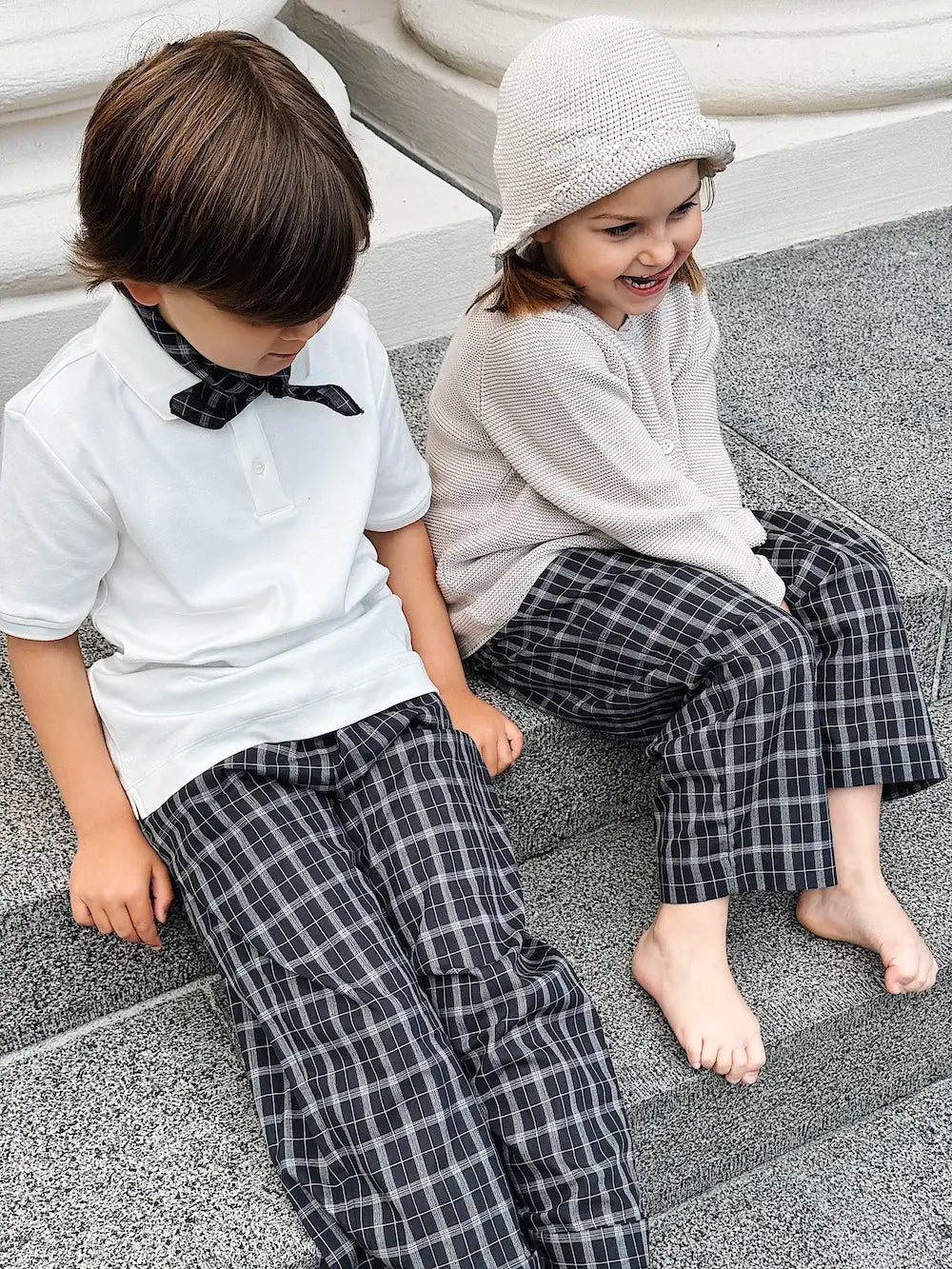 Boy and girl wearing Lalaby Frankie pants for kids in blue check organic cotton