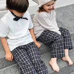 Boy and girl wearing Lalaby Frankie pants for kids in blue check organic cotton