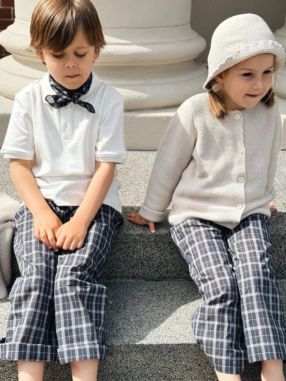 Boy and girl wearing Lalaby Frankie pants for kids in blue check organic cotton