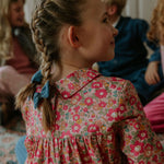 Girl wearing Lalaby 3-pack of hairbows for kids in whale blue, flamingo pink and tweedy check