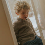 Boy wearing Lalaby Hugo v-neck for kids in a millet brown baby wool, yak and cashnere blend