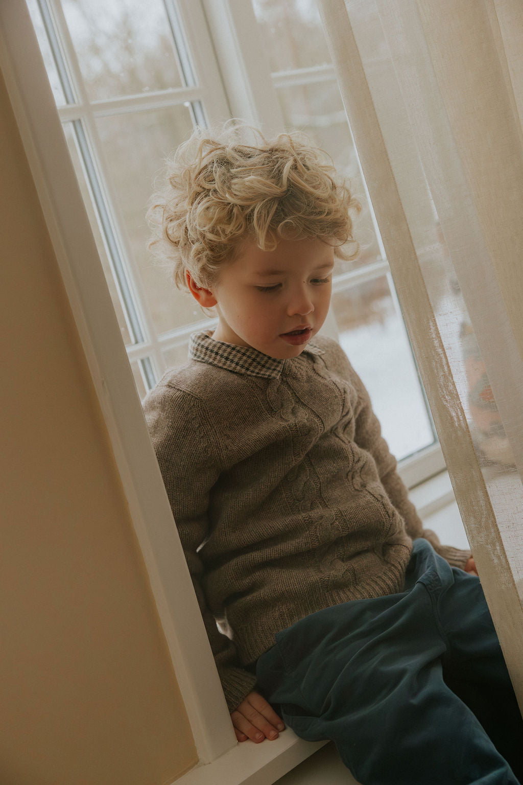 Boy wearing Lalaby Hugo v-neck for kids in a millet brown baby wool, yak and cashnere blend