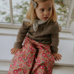 Girl wearing Lalaby Hugo v-neck for kids in a millet brown baby wool, yak and cashnere blend