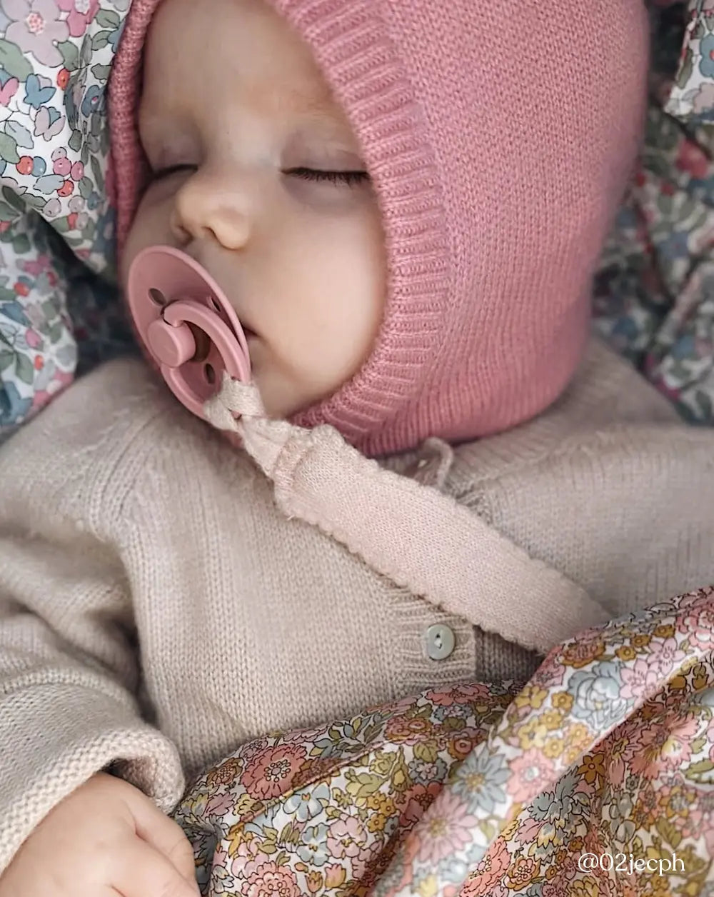 Baby wearing Lalaby Mio balaclava in sorbet pink cashmere