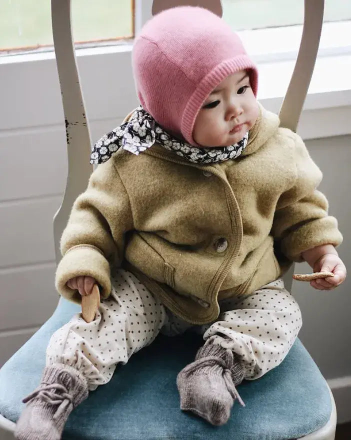 Baby wearing Lalaby Mio balaclava in sorbet pink cashmere