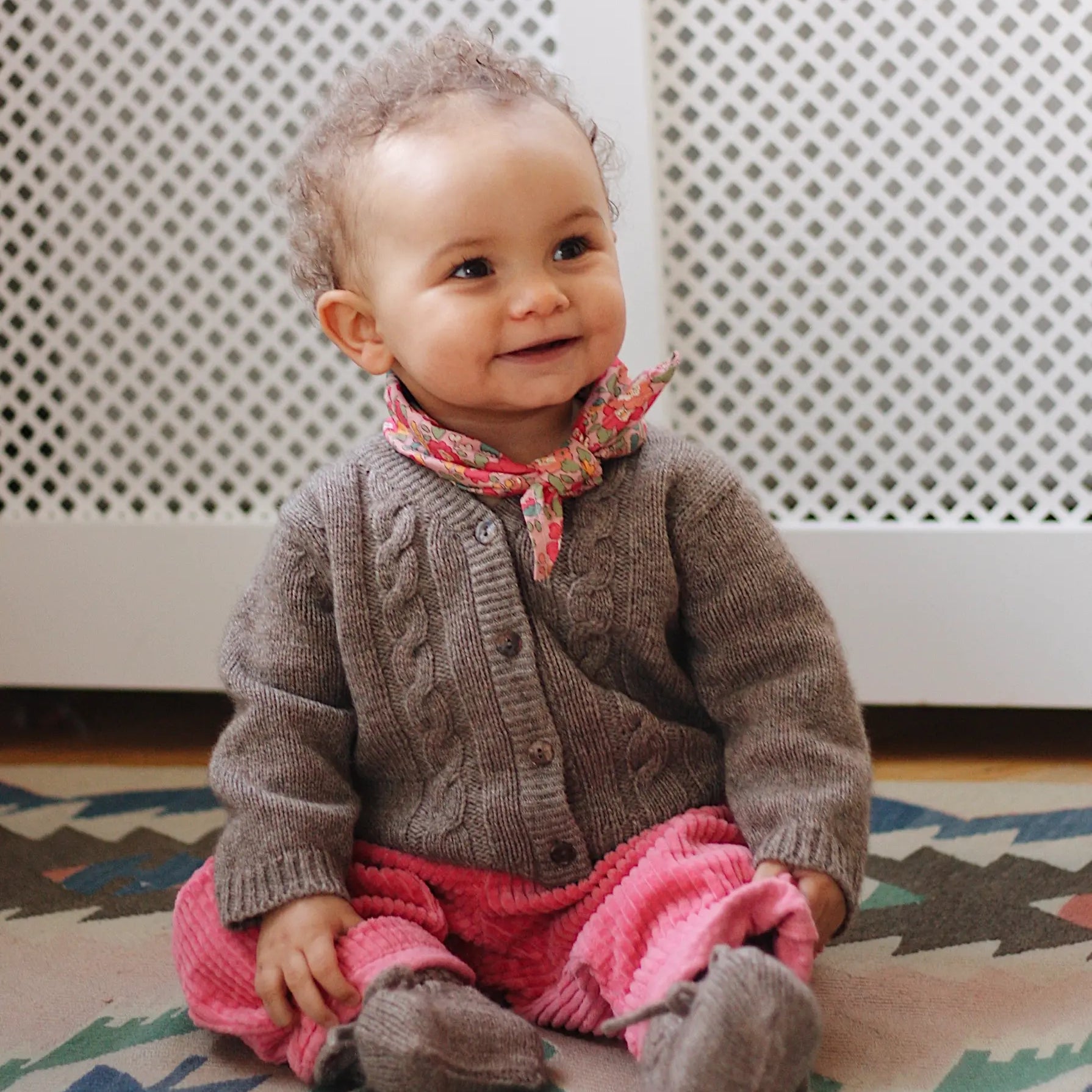 Baby girl wearing Lalaby Nomi baby cardigan in a millet brown baby wool, yak and cashmere blend