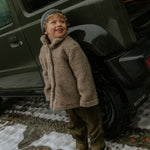 Boy wearing Lalaby Norr jacket for kids in grizzly brown merino wool