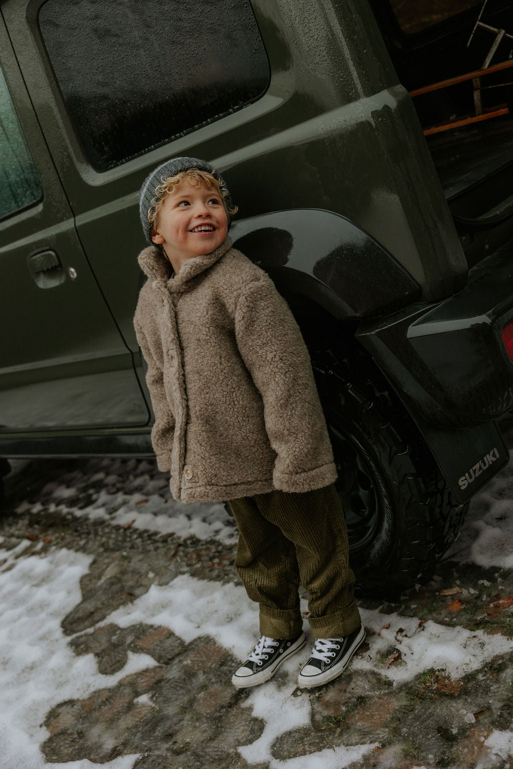 Boy wearing Lalaby Norr jacket for kids in grizzly brown merino wool