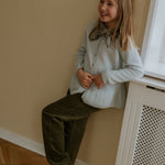Girl wearing Lalaby Oda cardigan in bluey light blue cashmere