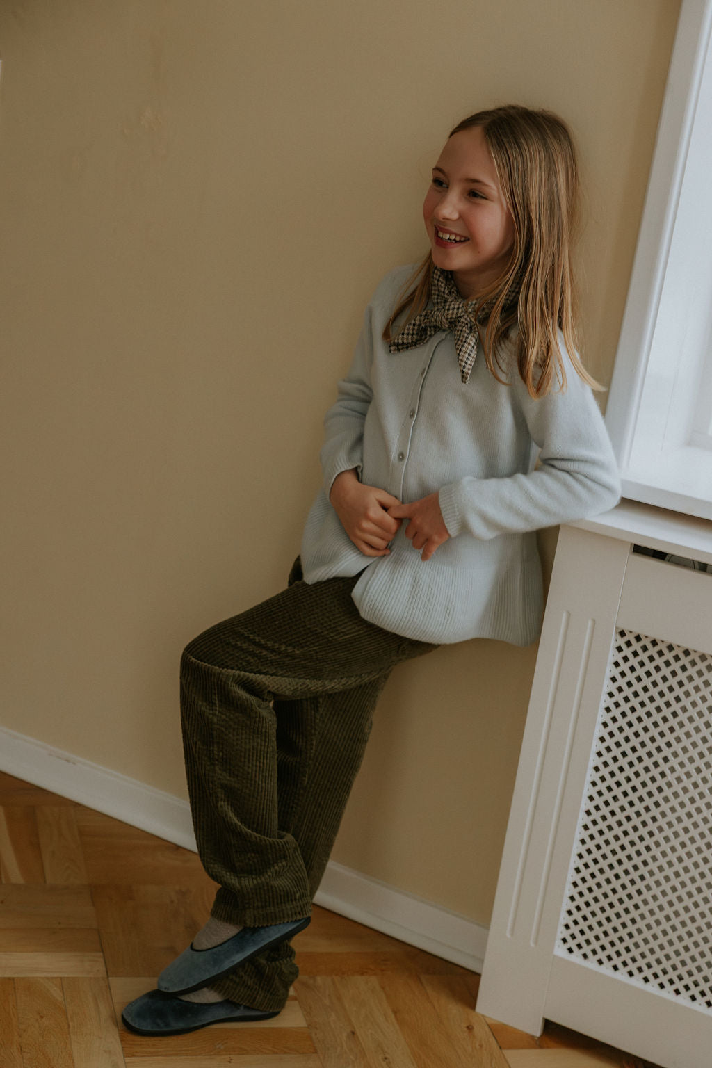 Girl wearing Lalaby Oda cardigan in bluey light blue cashmere