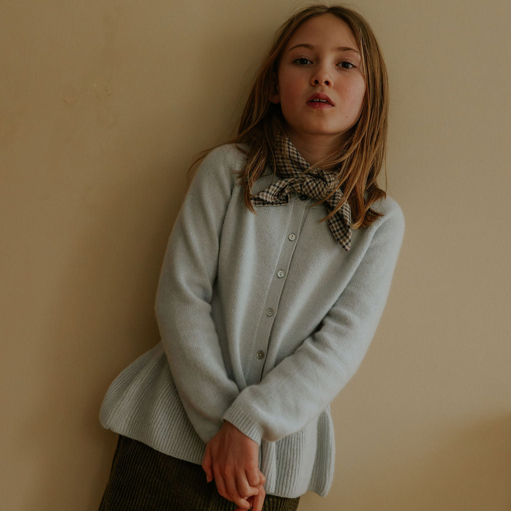 Girl wearing Lalaby Oda cardigan in bluey light blue cashmere