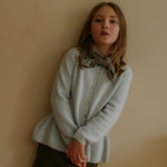 Girl wearing Lalaby Oda cardigan in bluey light blue cashmere