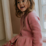 Girl wearing Lalaby Oda cardigan in sorbet pink cashmere